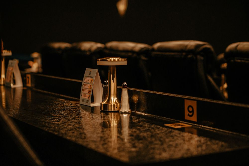 Close-up of sound mixing board faders in dark ambient lighting.