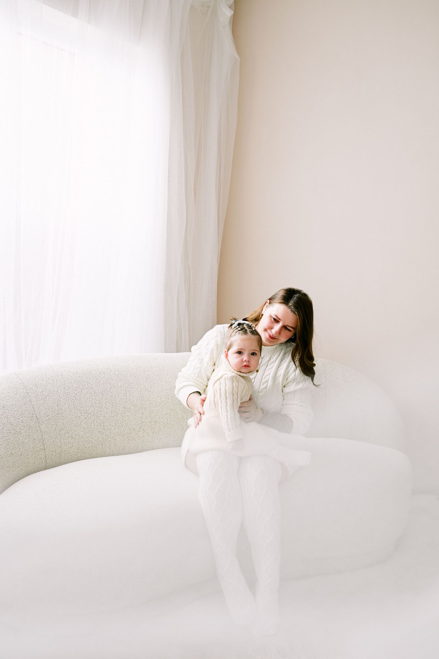 Candid lifestyle photos of mother and child bonding on a light colored sofa.