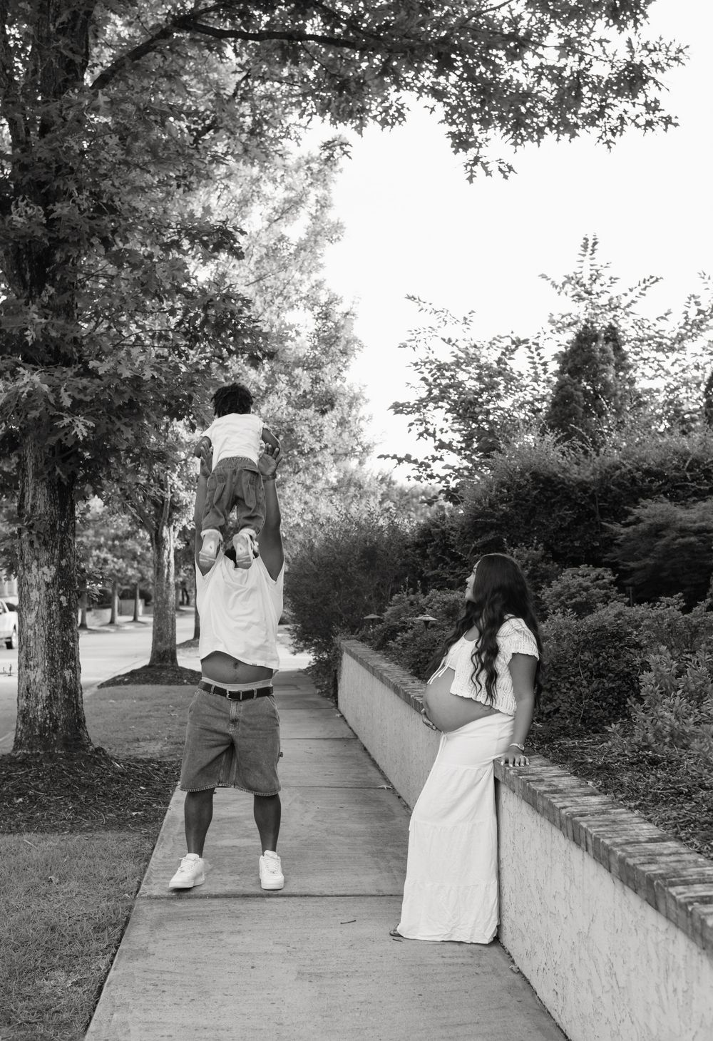A sequence of black and white photos showing a couple walking along a tree-lined path in an outdoor setting.