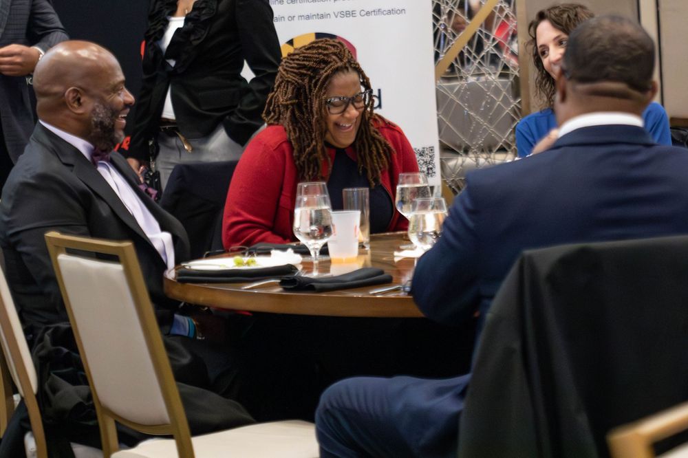 Business professionals having a discussion around a table during a meeting or networking event.
