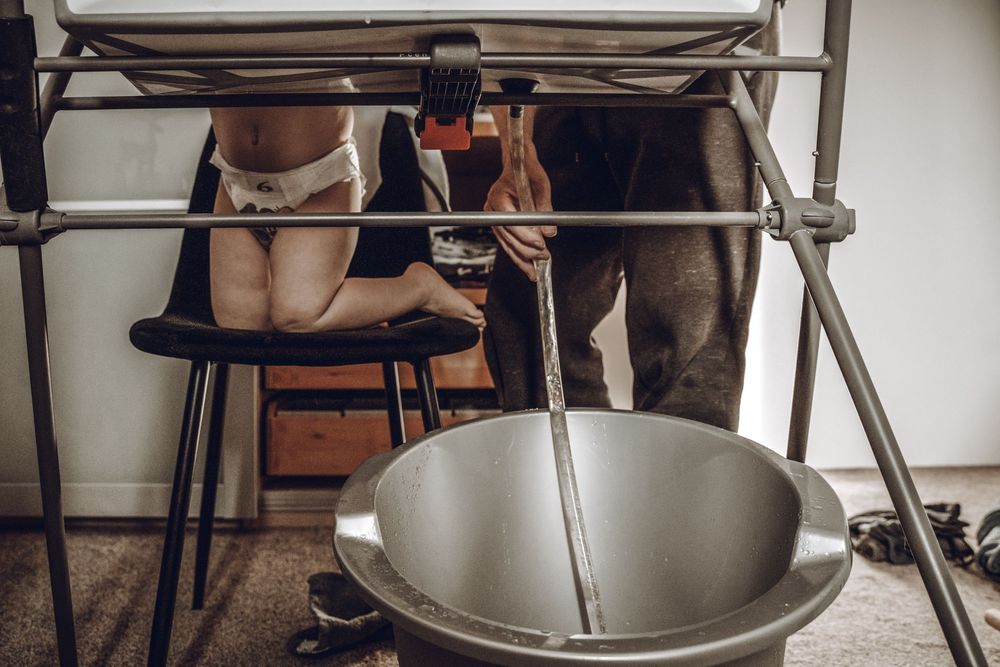 Commercial kitchen equipment with large stainless steel mixing bowls and dough hooks on industrial stands.