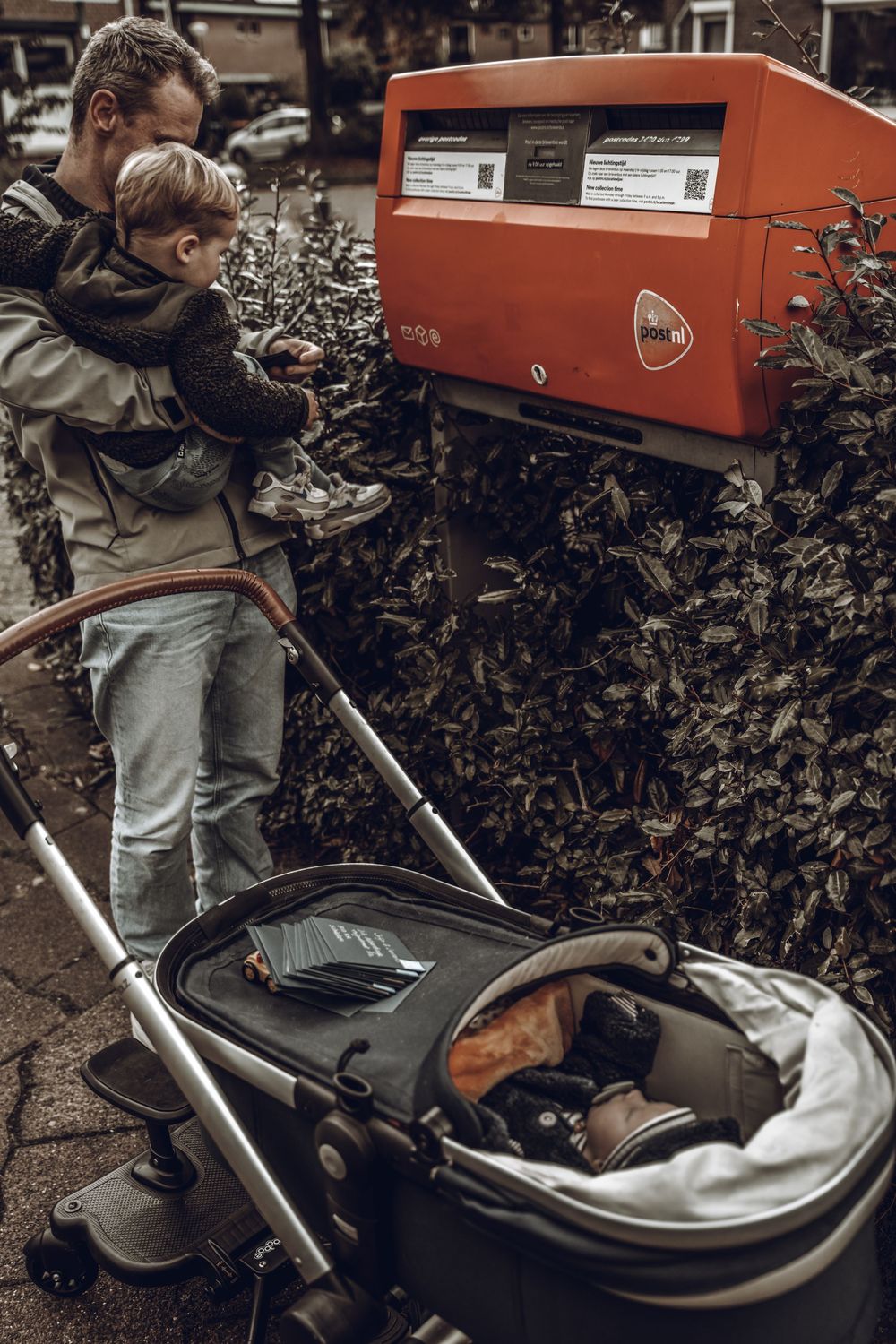 Vintage orange DR trimmer being used to trim hedges and bushes in a garden setting.