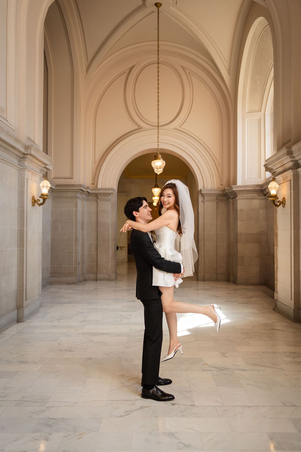 A romantic moment captured in an elegant marble hallway with arched ceilings and classic architectural details.