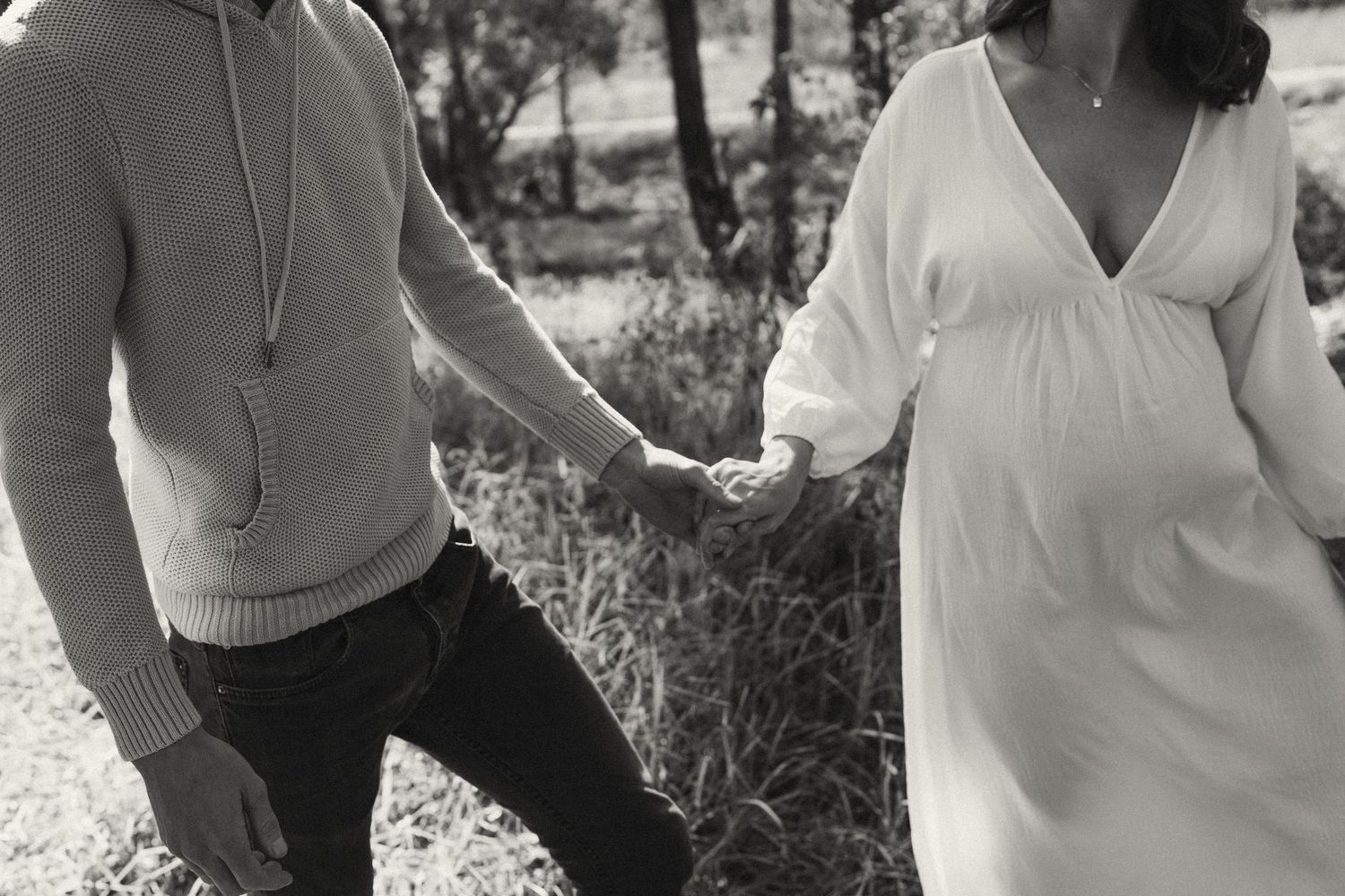 Black and white series of couple in casual attire walking through nature.