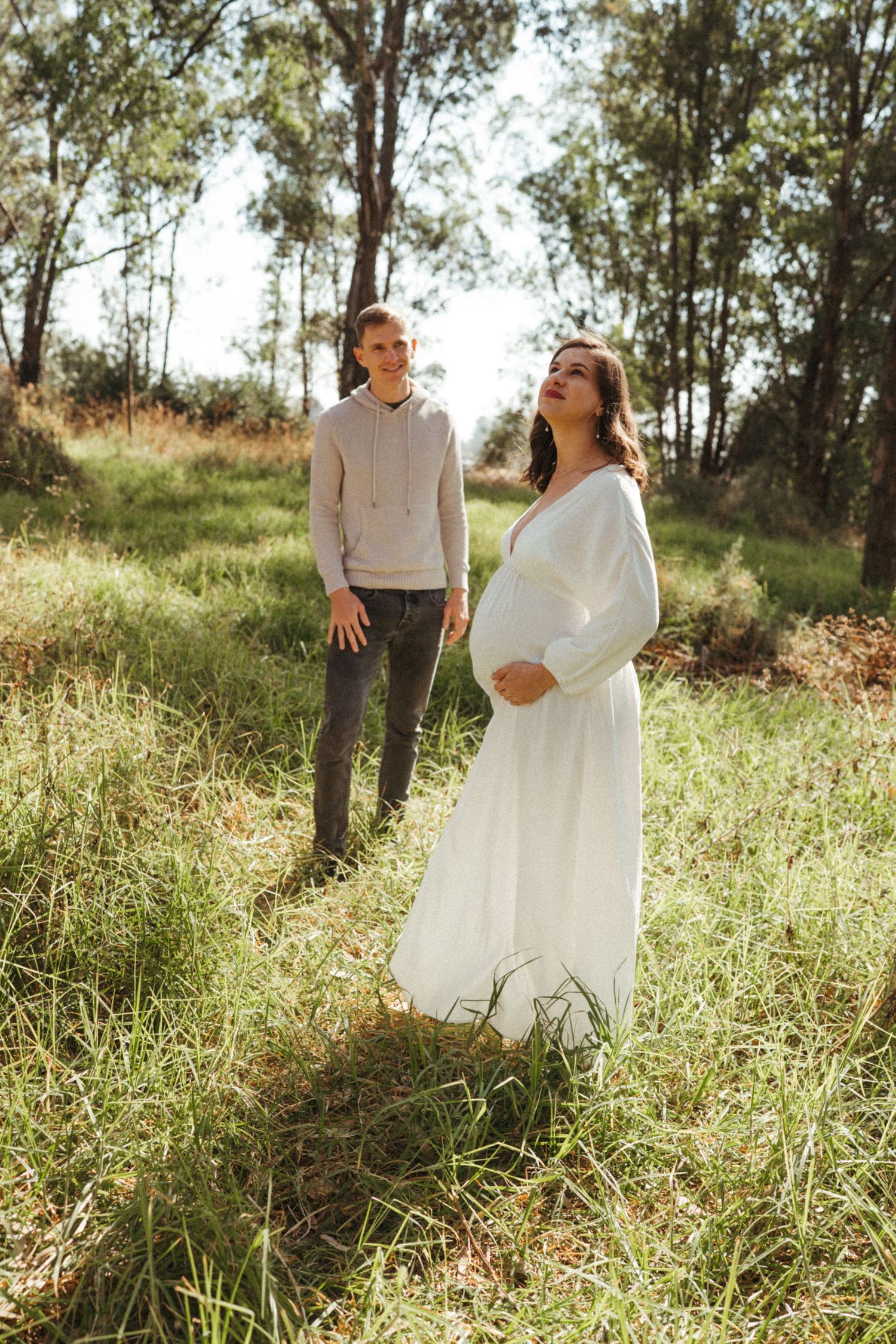 A tender moment captured between a couple in a natural outdoor setting with golden light.