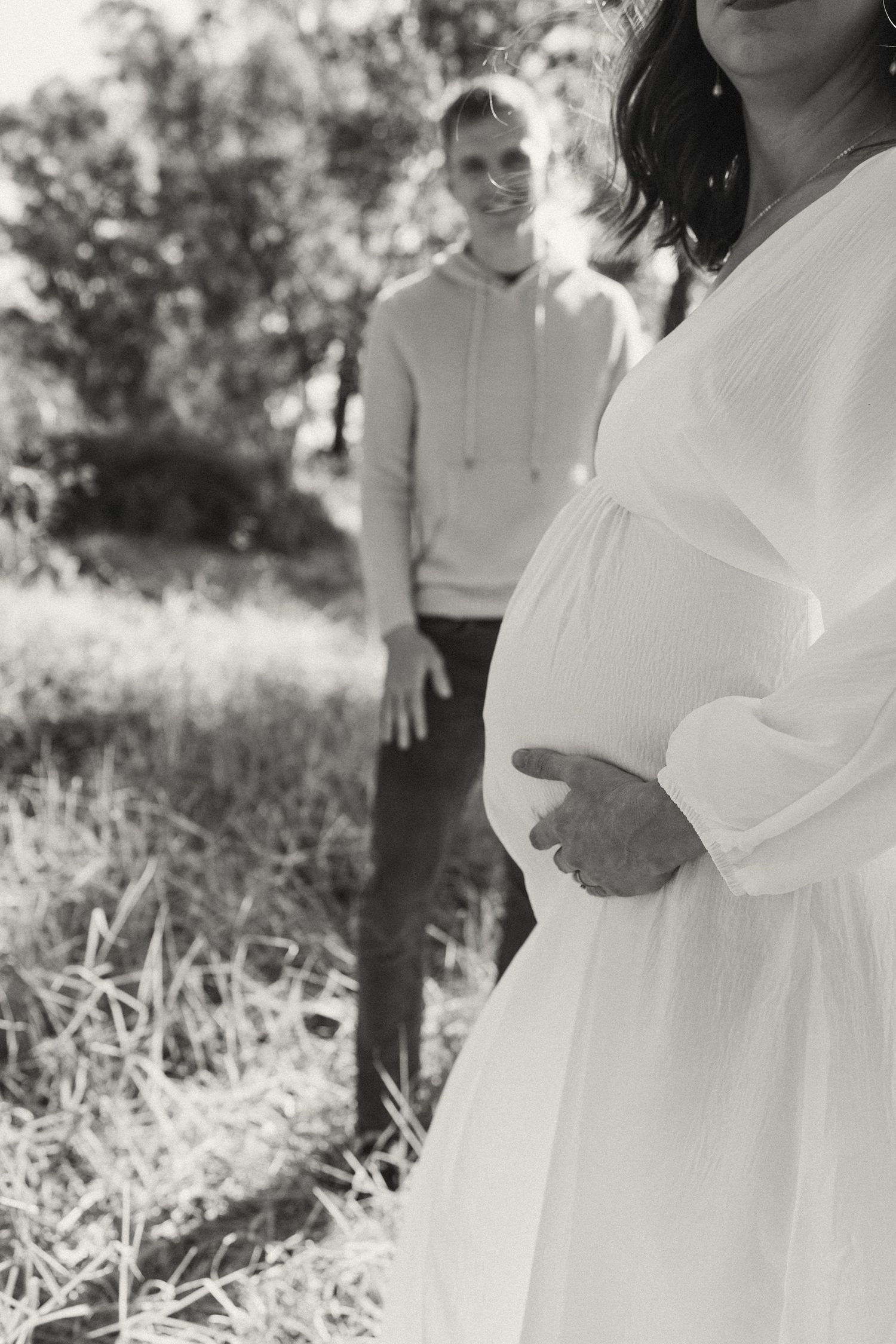 Black and white photo of a couple in a serene outdoor setting with natural lighting.