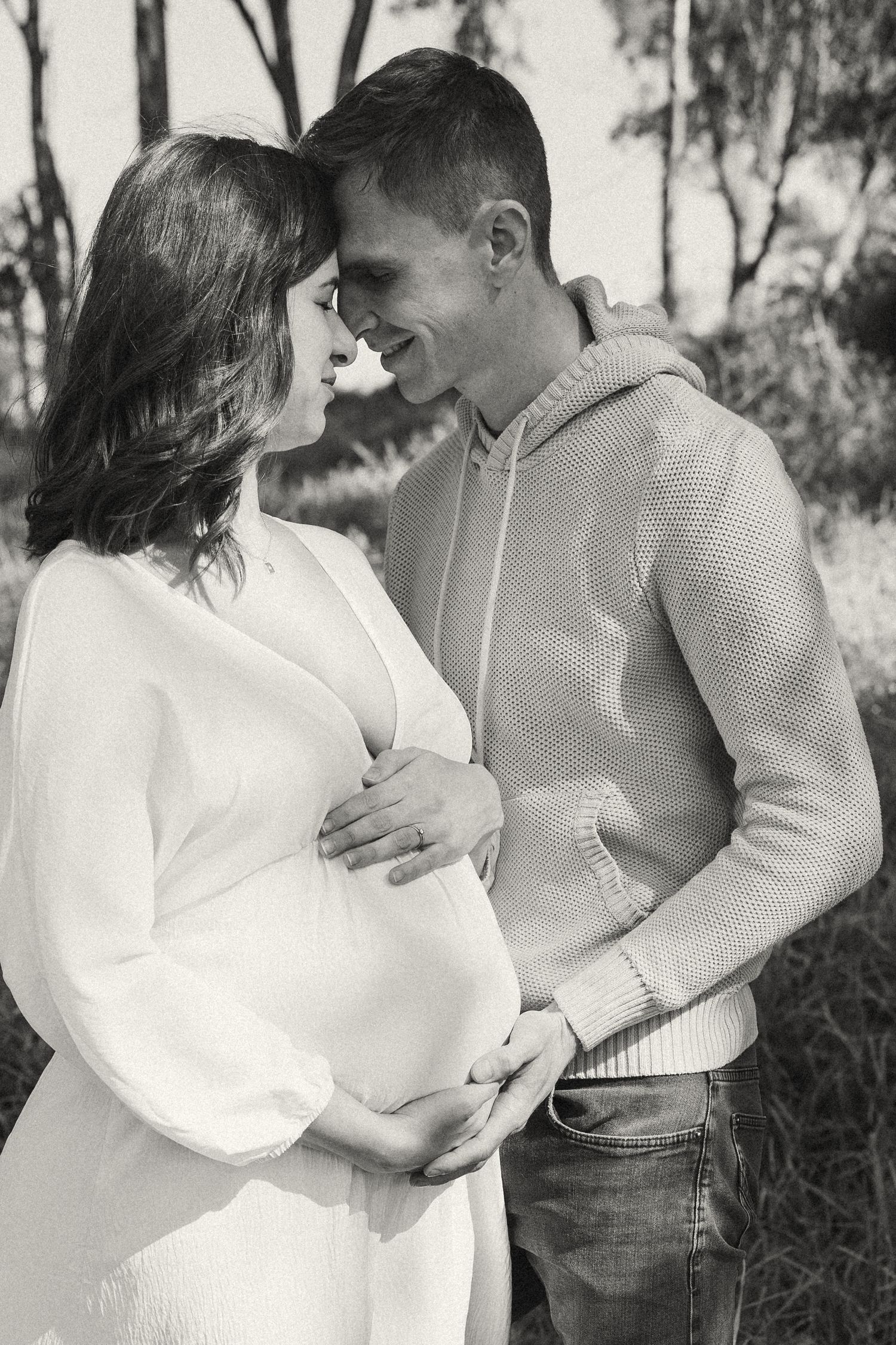 A black and white portrait of a couple sharing intimate moments in casual attire.