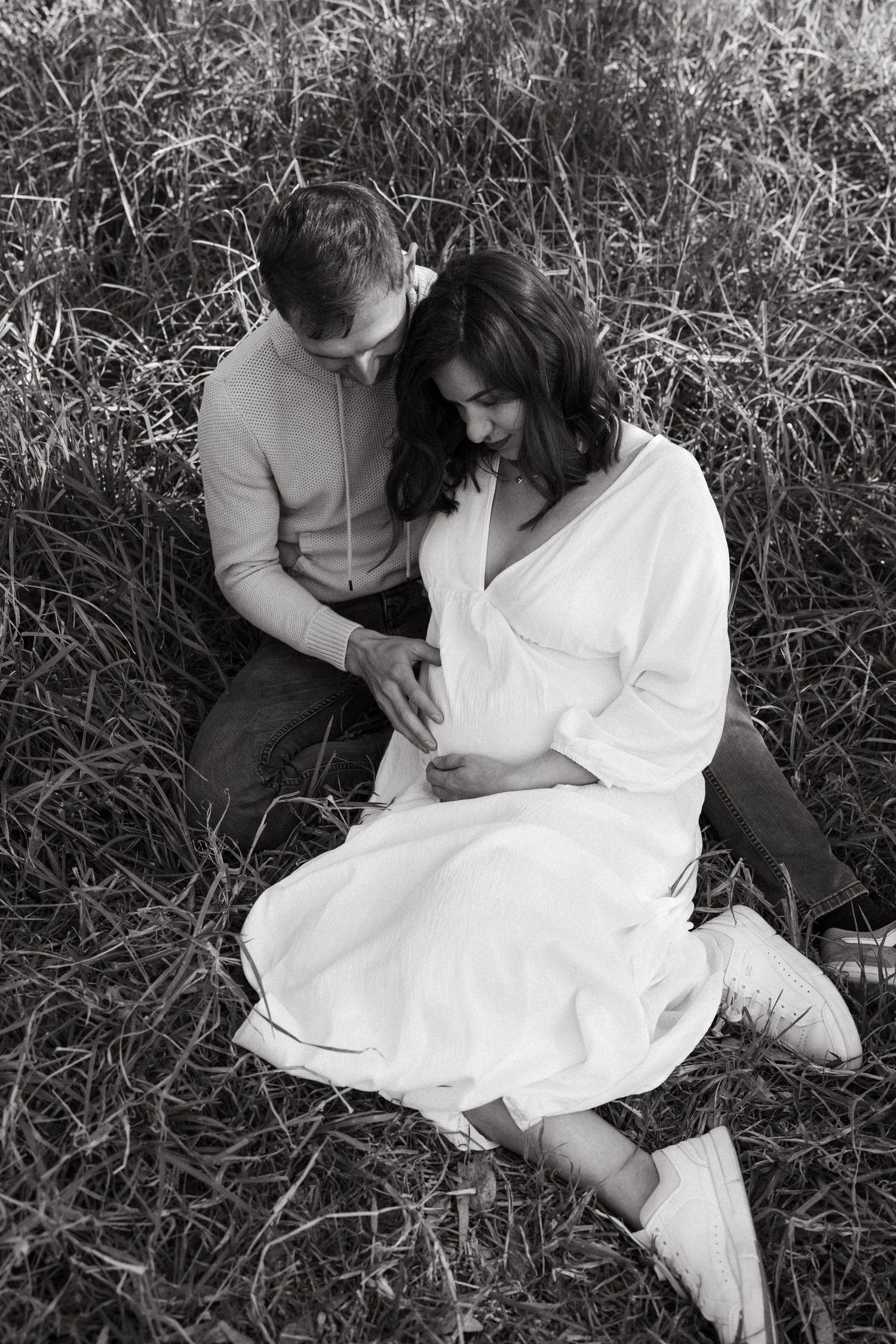 Romantic black and white photo series of a couple lying in tall grass.