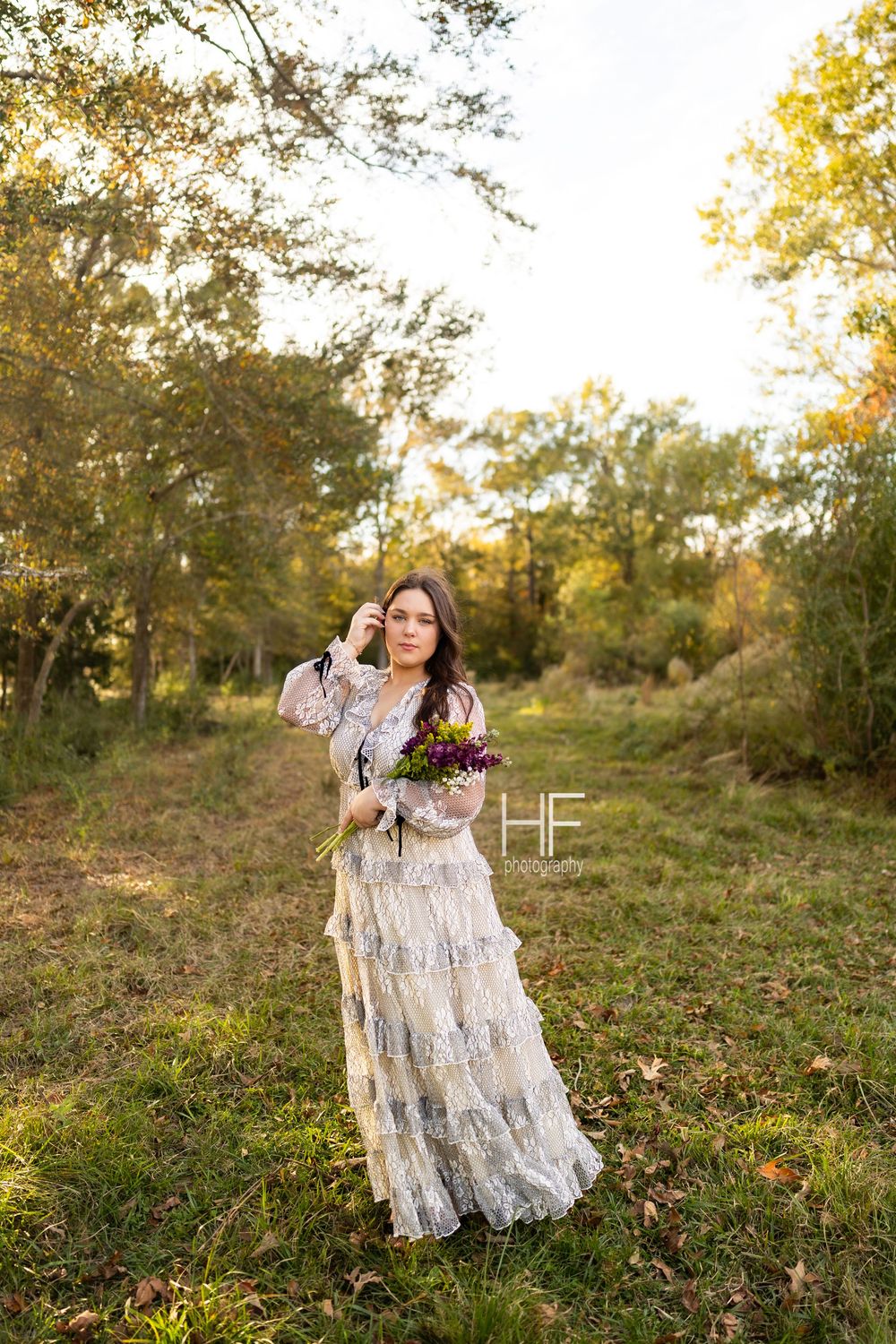 A serene forest portrait featuring a vintage-inspired lace dress and autumn scenery.