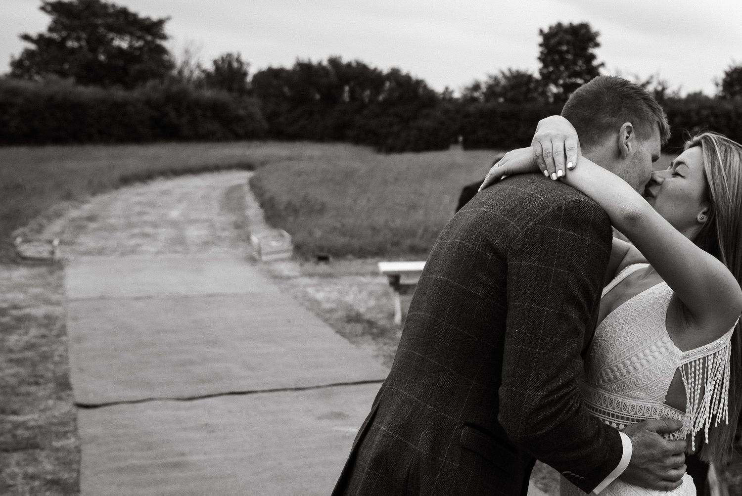 Black and white candid moment of a couple celebrating outdoors.