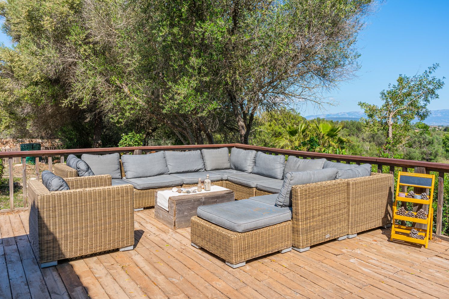 A panoramic view of a residential rooftop with brown parapet walls and HVAC equipment under bright blue sky.