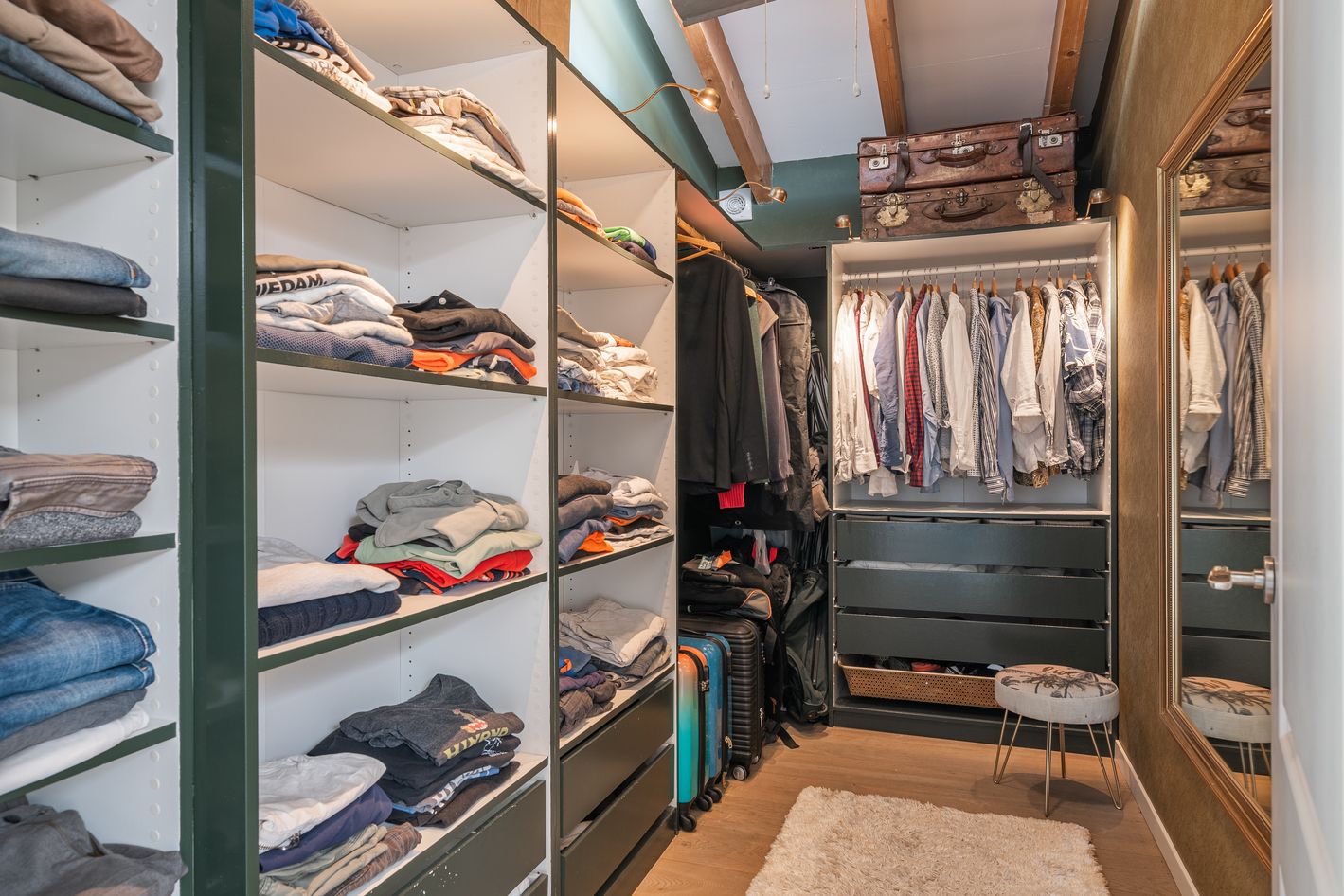 Modern walk-in closet with built-in shelving and hanging rods showcasing organized clothing and accessories.