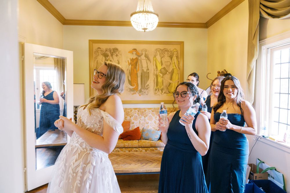 Wedding party getting ready in an elegant room with natural light streaming through windows.