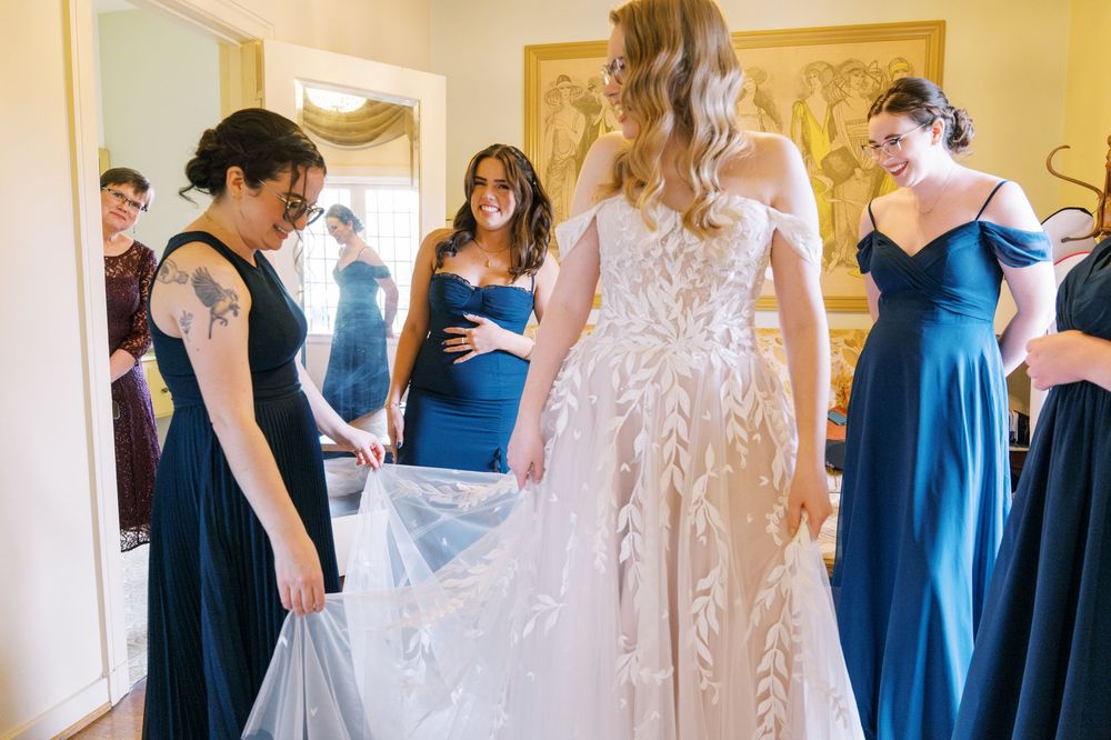 Wedding party in navy blue and white dresses lined up for a group photo.