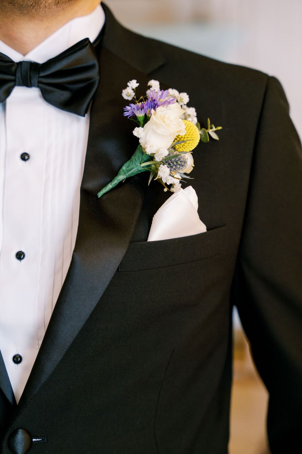 Close-up shots of black tuxedo lapels with white and purple floral boutonnieres.