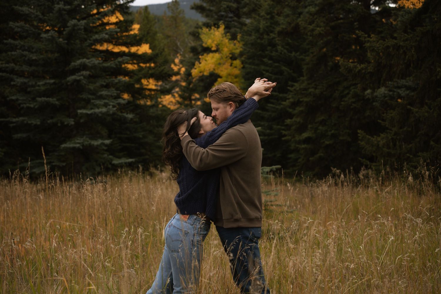 Close-up of hands reaching towards each other in a dreamy outdoor setting.