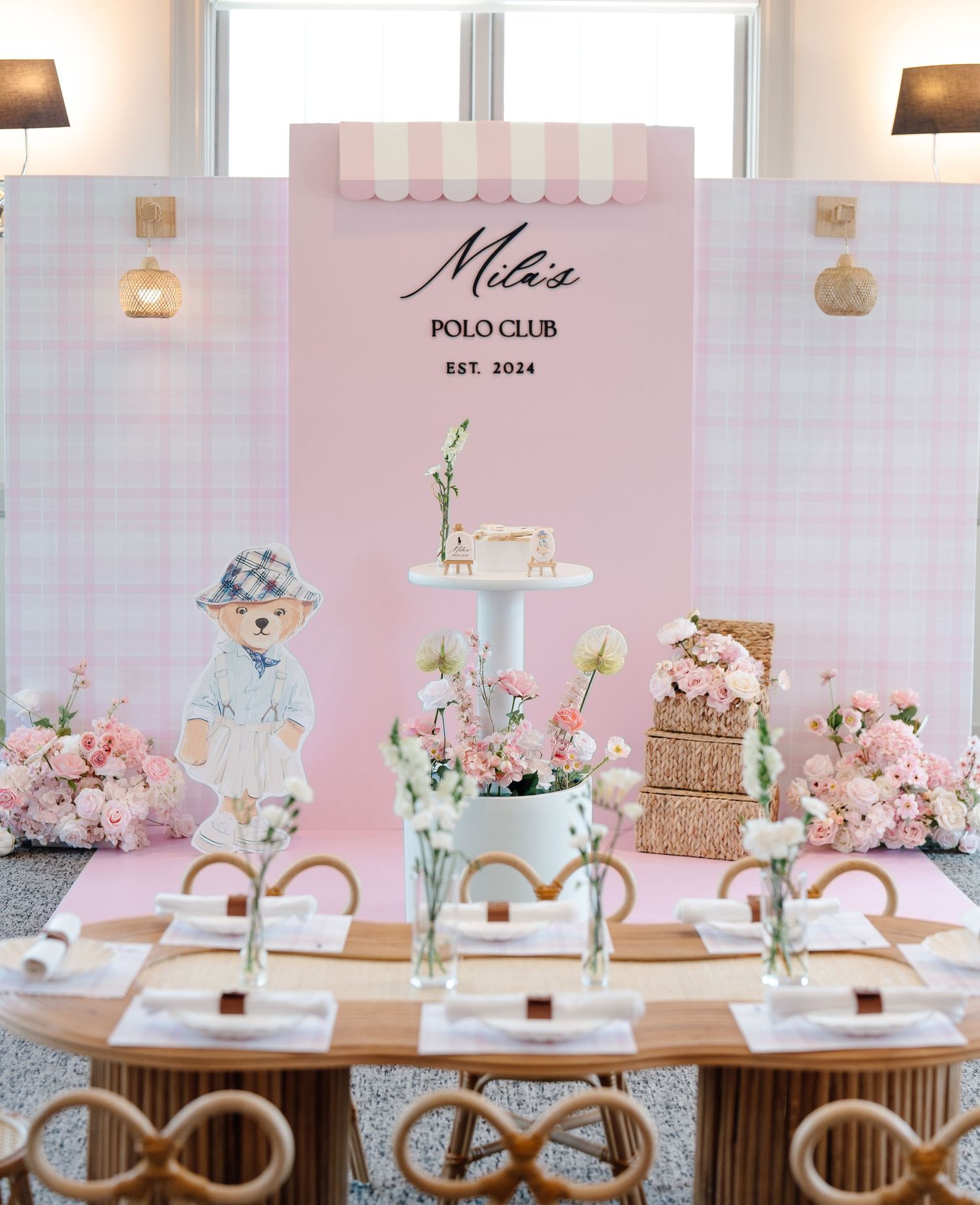 Pink Polo Club themed birthday party setup with floral decorations and cake display.
