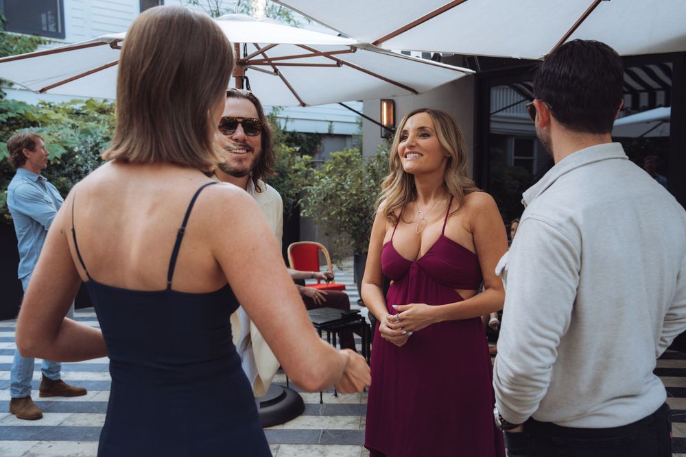 Guests mingling at an outdoor social event under covered patio space.