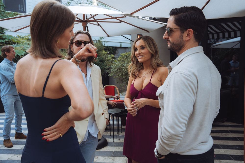 People socializing at an outdoor party with burgundy and black attire.