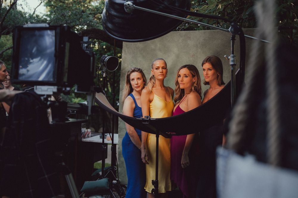 Behind-the-scenes photography setup with lighting equipment and cameras in a dark room.