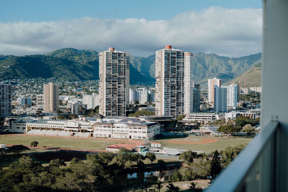 Scenic view of urban skyline against mountain backdrop with white pillars in foreground.