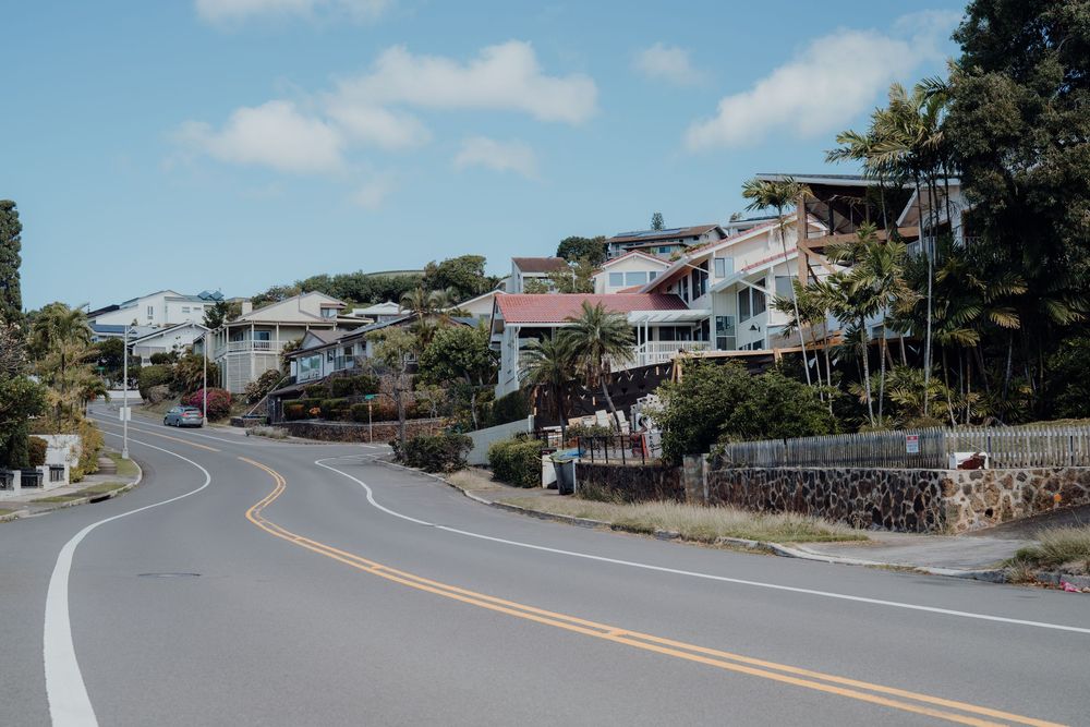 Winding coastal road with yellow dividing lines curves along the hillside.