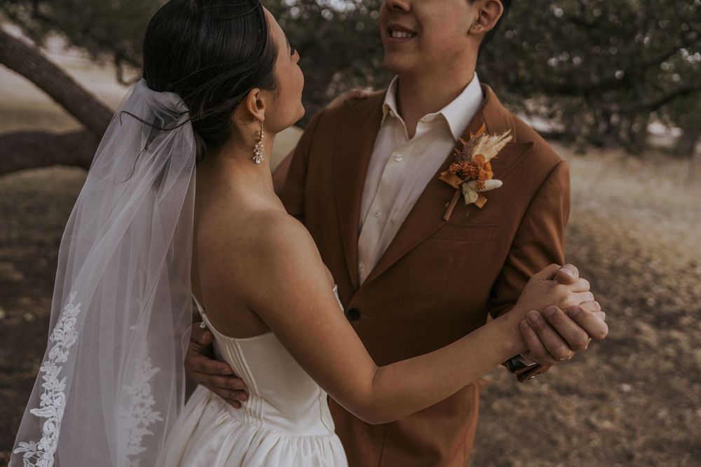 Romantic wedding couple embracing in outdoor setting with autumn tones.