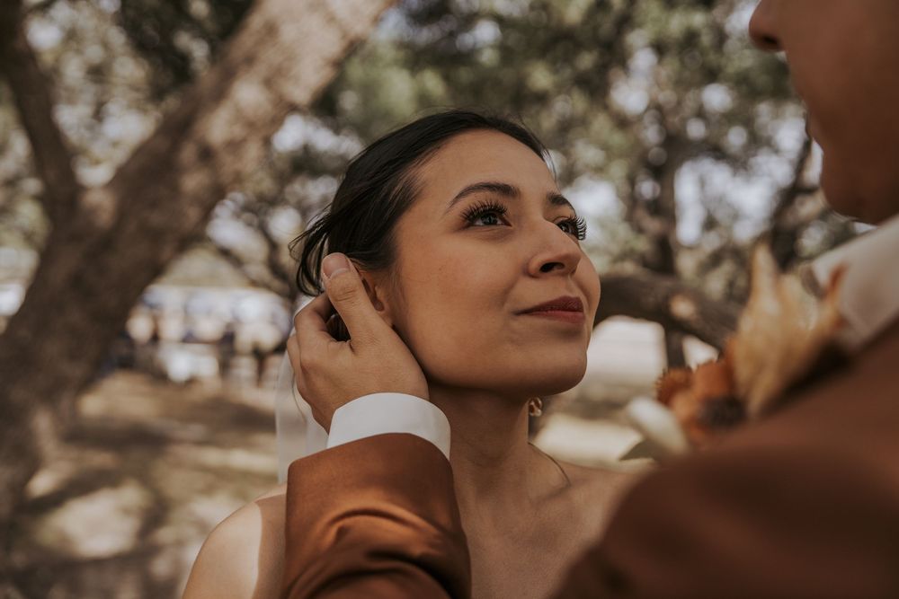 Artistic close-up wedding portrait with warm natural lighting and soft focus.
