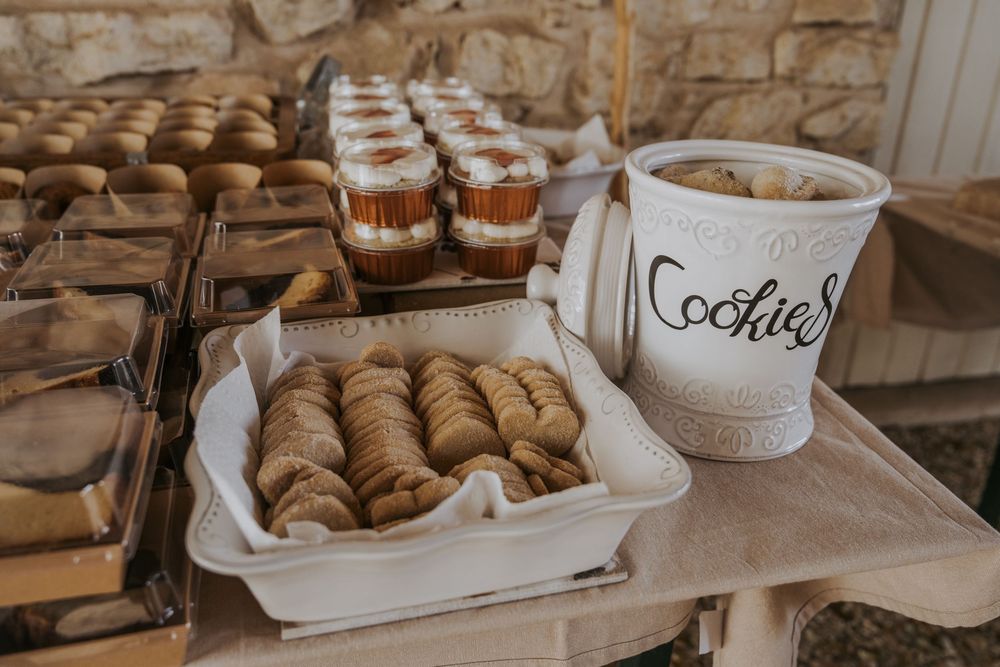 Rustic dessert table with pastries and treats displayed on white serving platters.