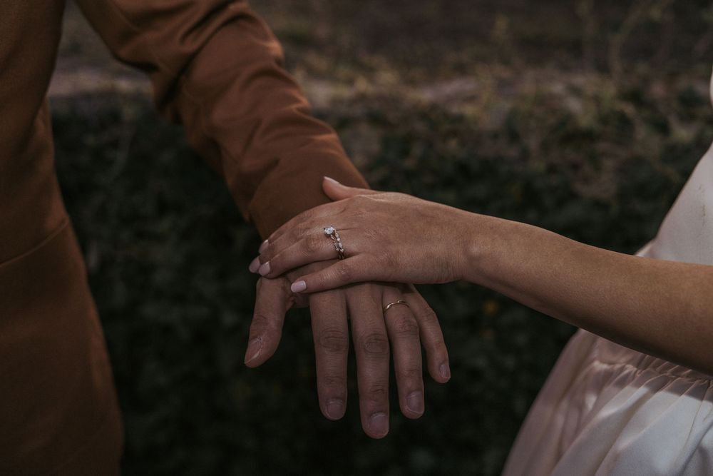 Close-up of hands during an intimate wedding ceremony moment.
