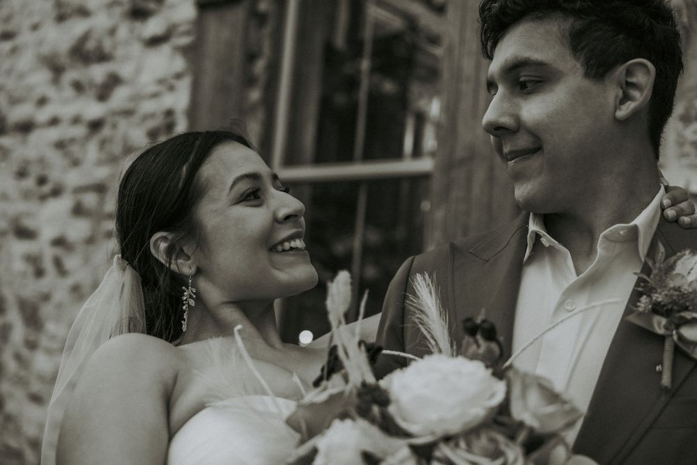 Black and white candid wedding moment captured in natural window light.