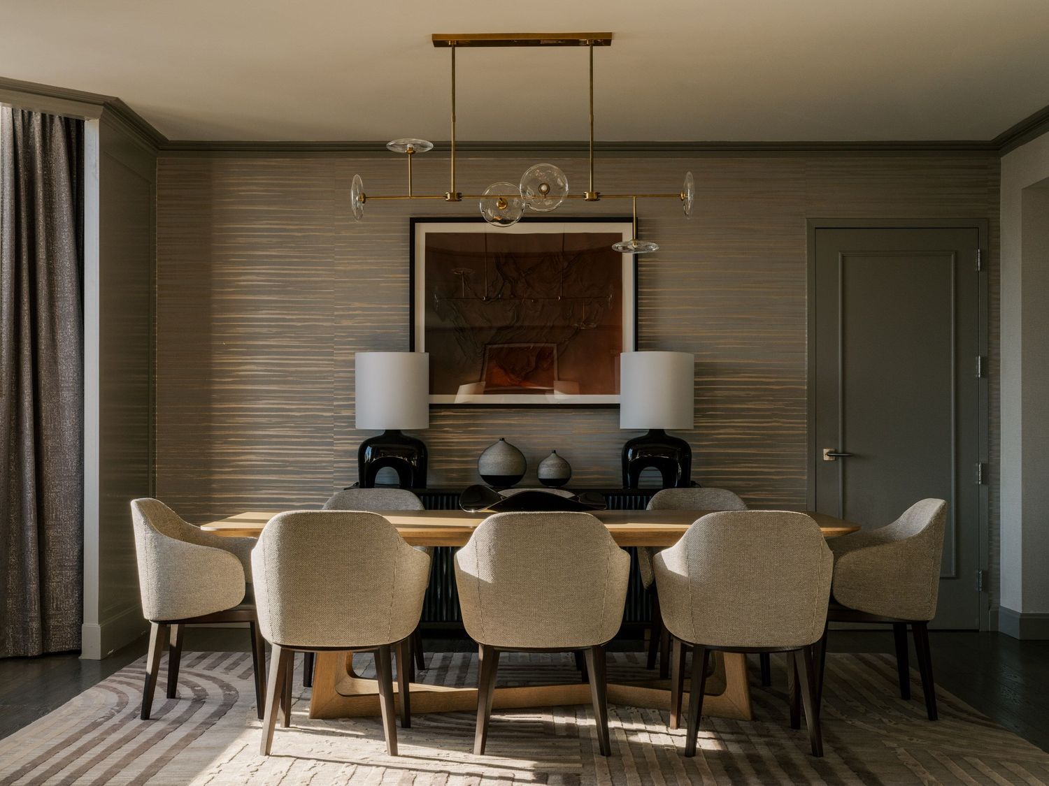 Modern dining room with white chairs, pendant lighting, and textured wall panels in contemporary design.