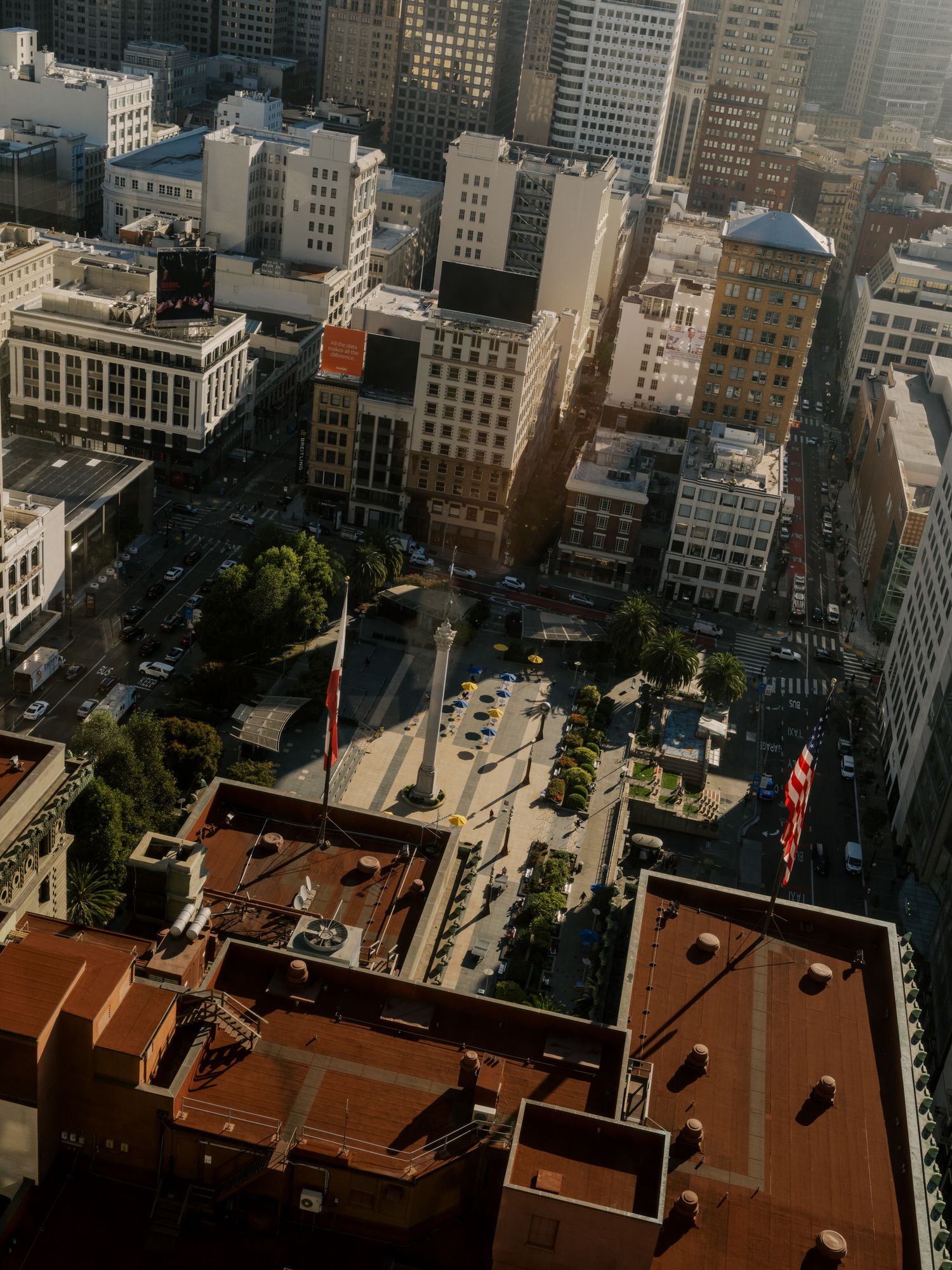 Aerial view of city buildings with orange-tinted rooftops and urban architecture.