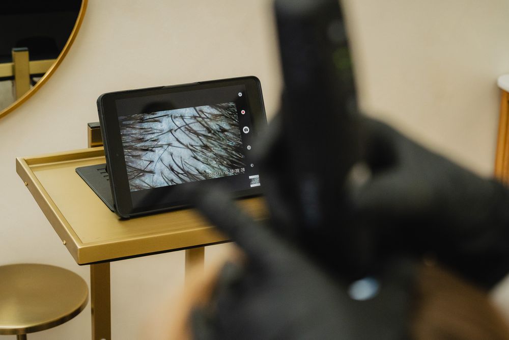 Jill doing a trichology scalp exam with a digital tool during her Eagle Rock branding photoshoot.