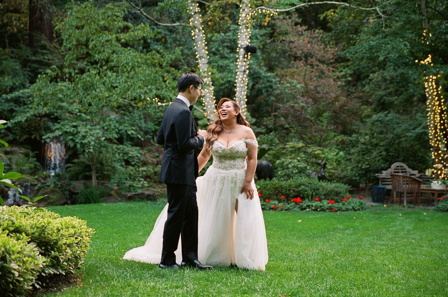 Wedding ceremony taking place in a lush garden setting with natural greenery and trees in the background.
