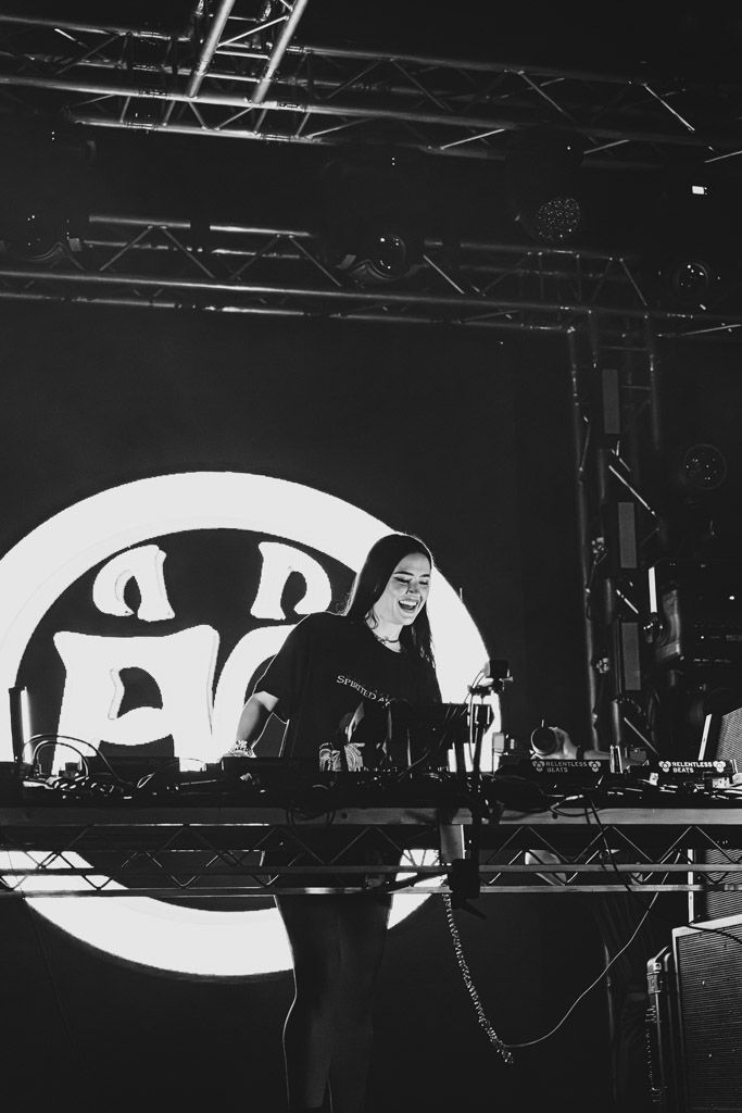 Black and white panoramic view of a stage setup with large illuminated eye-shaped projection screens in a dark venue.