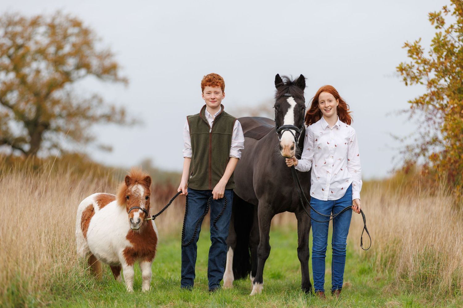 A horse and its rider enjoy an outdoor photoshoot session near rustic wooden fencing on a sunny day.