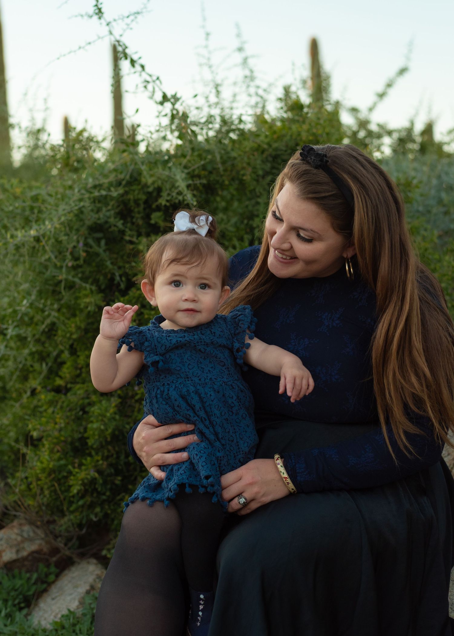A sweet moment between parent and child against a backdrop of desert plants.