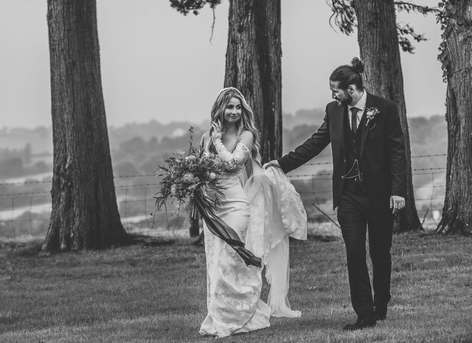 A black and white wedding photo sequence shows a couple walking together among tall trees in a park setting.