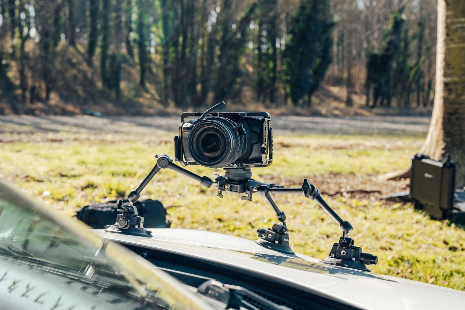 Professional camera mounted on car hood rig for automotive filming.