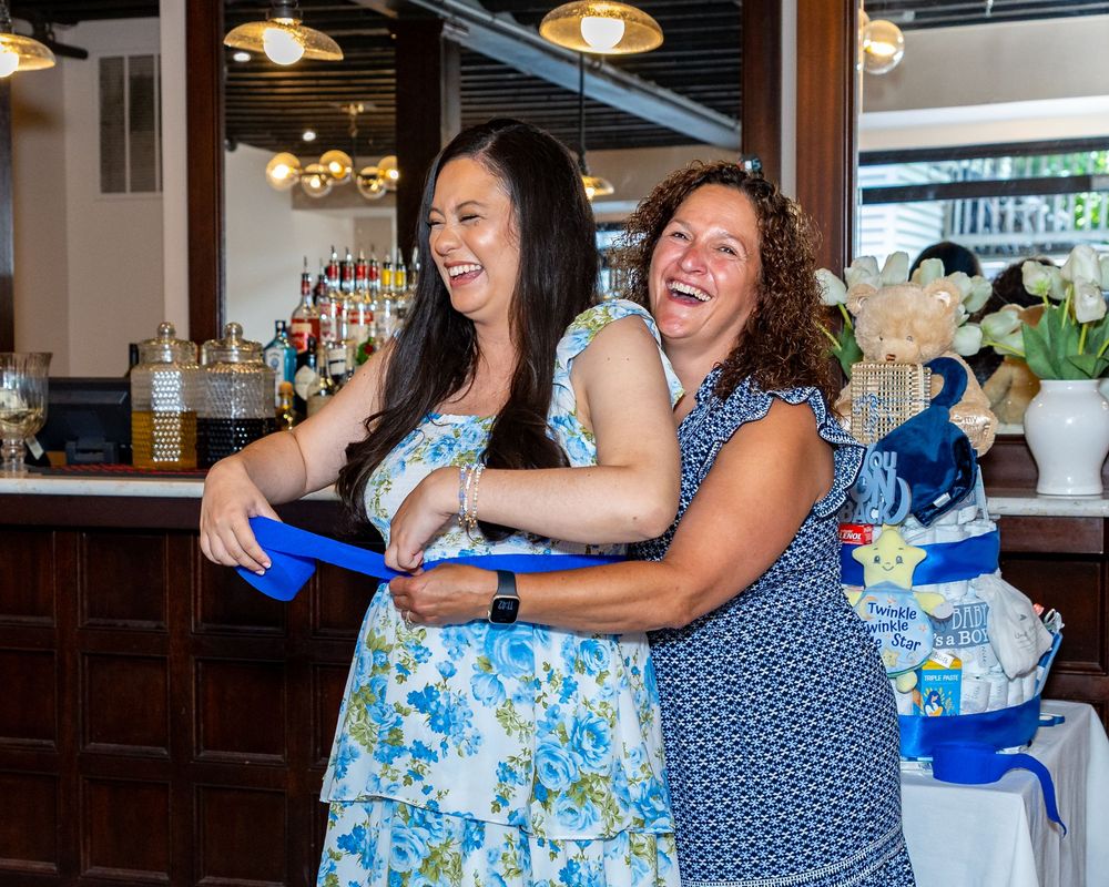 A baby shower in Boston, MA professional photography to capture genuine joy and candid moments.  Mom to be laughs during belly measuring