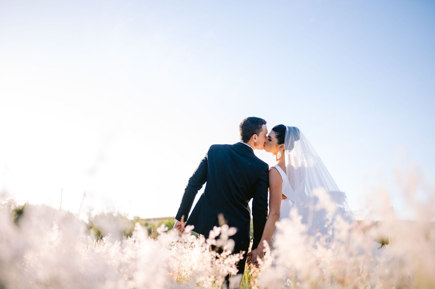 Romantic couple shares intimate moment in front of scenic mountain landscape during golden hour.
