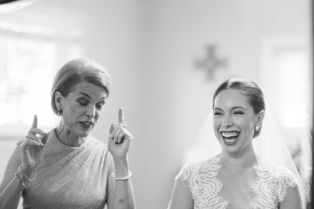 A candid black and white moment showing joyful laughter and animated expressions between two people at a formal event.