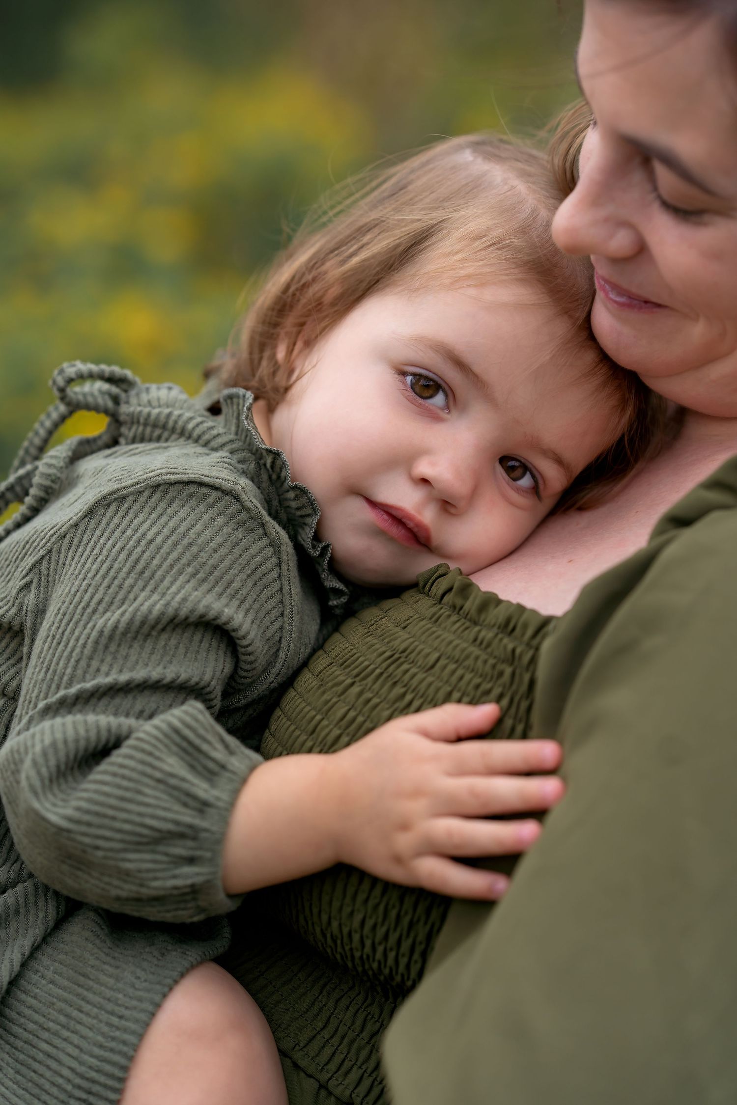 Tender family moments captured in a series of close-up portraits showing affectionate embraces in olive green attire.