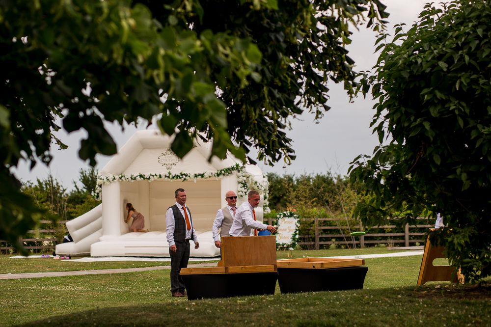 Scenic outdoor wedding venue with white tent and trees in background.