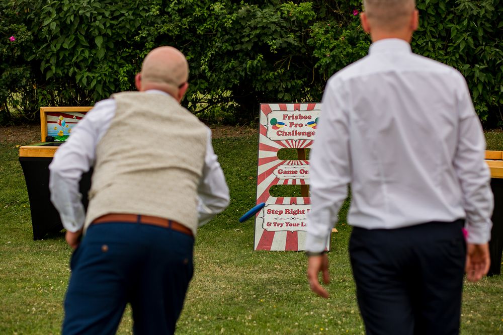 Wedding guests playing outdoor lawn games at garden reception.