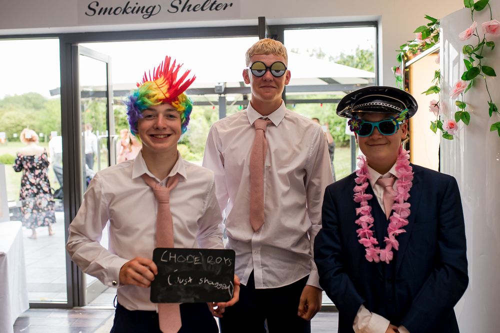 Group photo with party props and colorful accessories at an indoor venue.