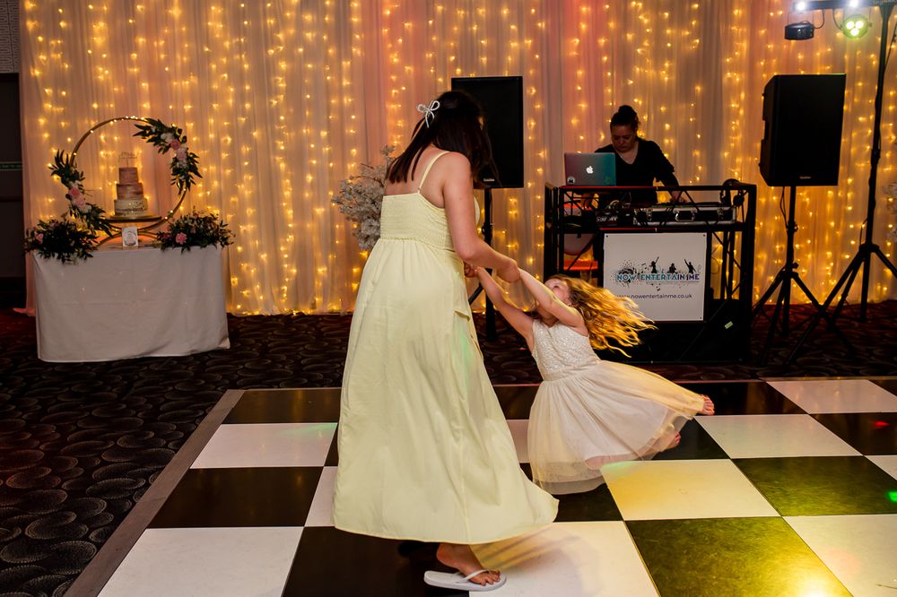 Wedding reception dance floor with fairy light backdrop and checkered flooring.