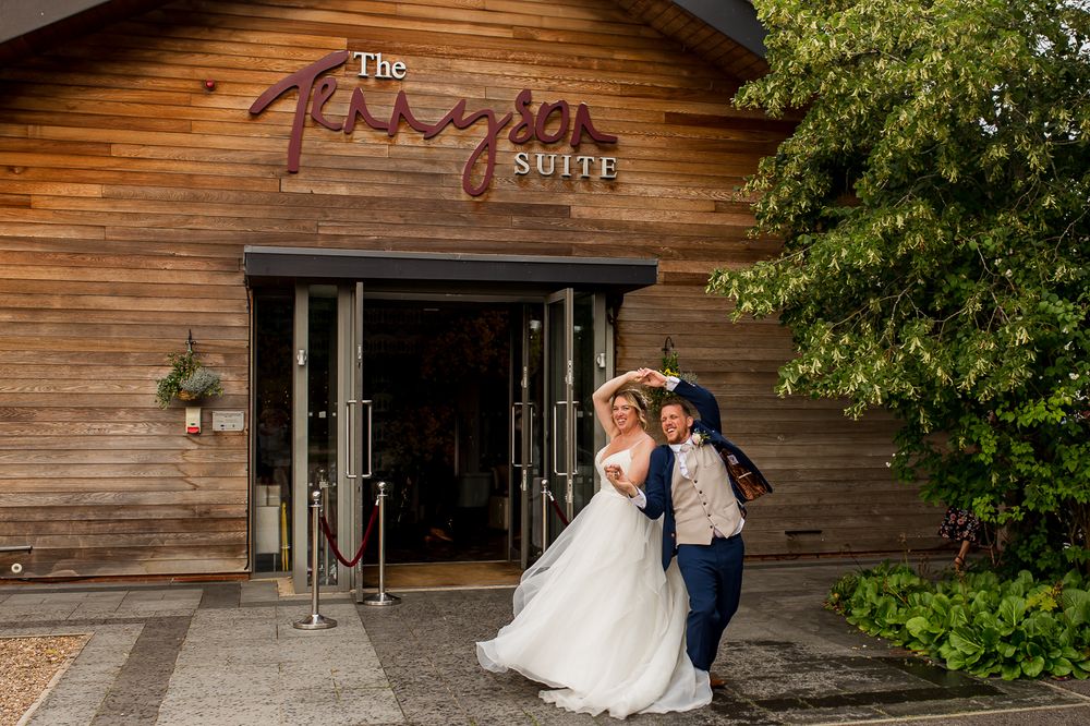 Couple shares intimate moment while entering The Paragon Barn wedding venue.