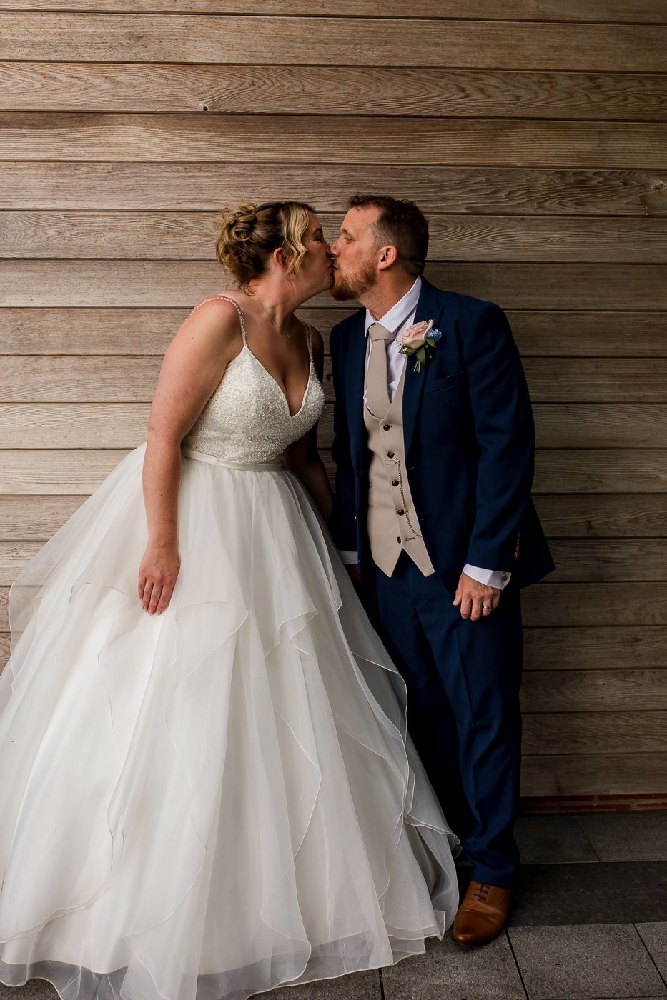 Intimate wedding portrait series showing couple sharing tender moments against rustic wood paneling.